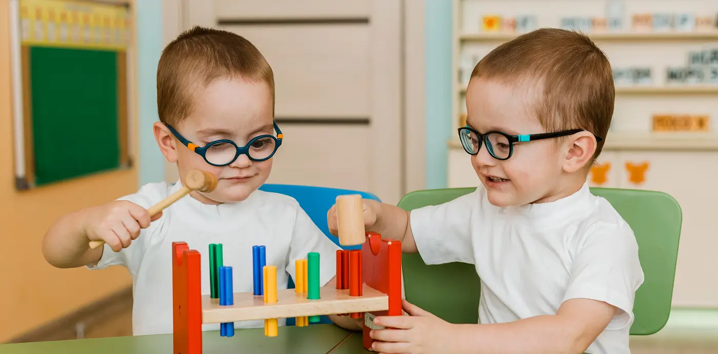 Dos niños jugando juntos con un juego de encajar piezas